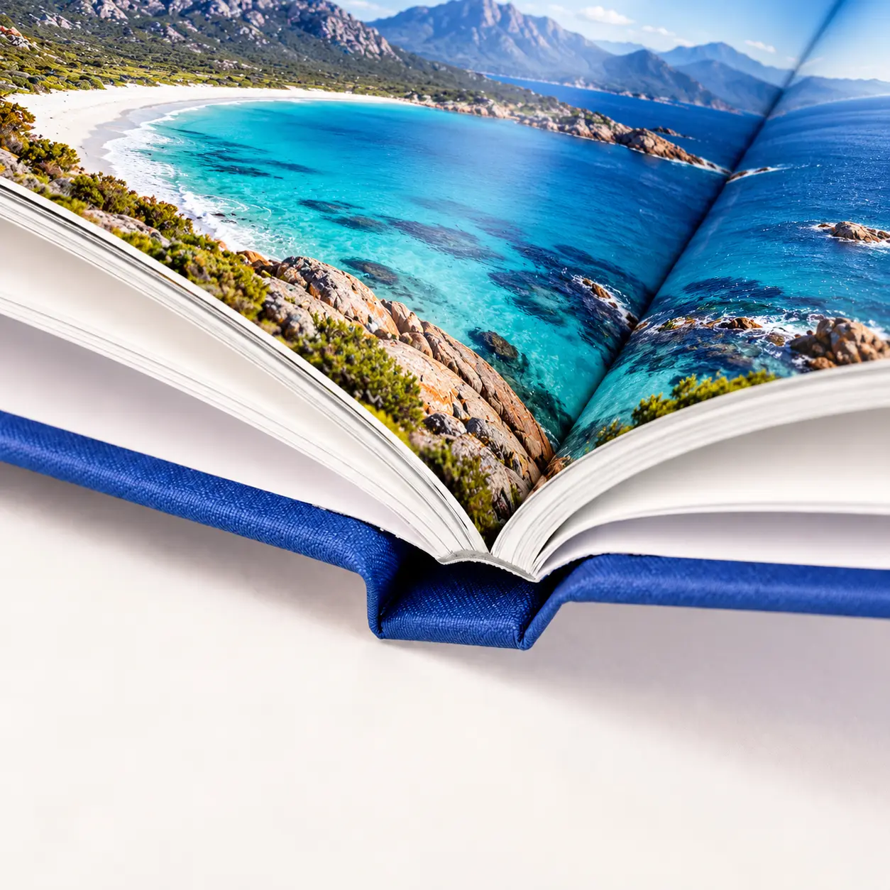 An open hardcover photography book showing a coastal landscape across a full-bleed two-page spread